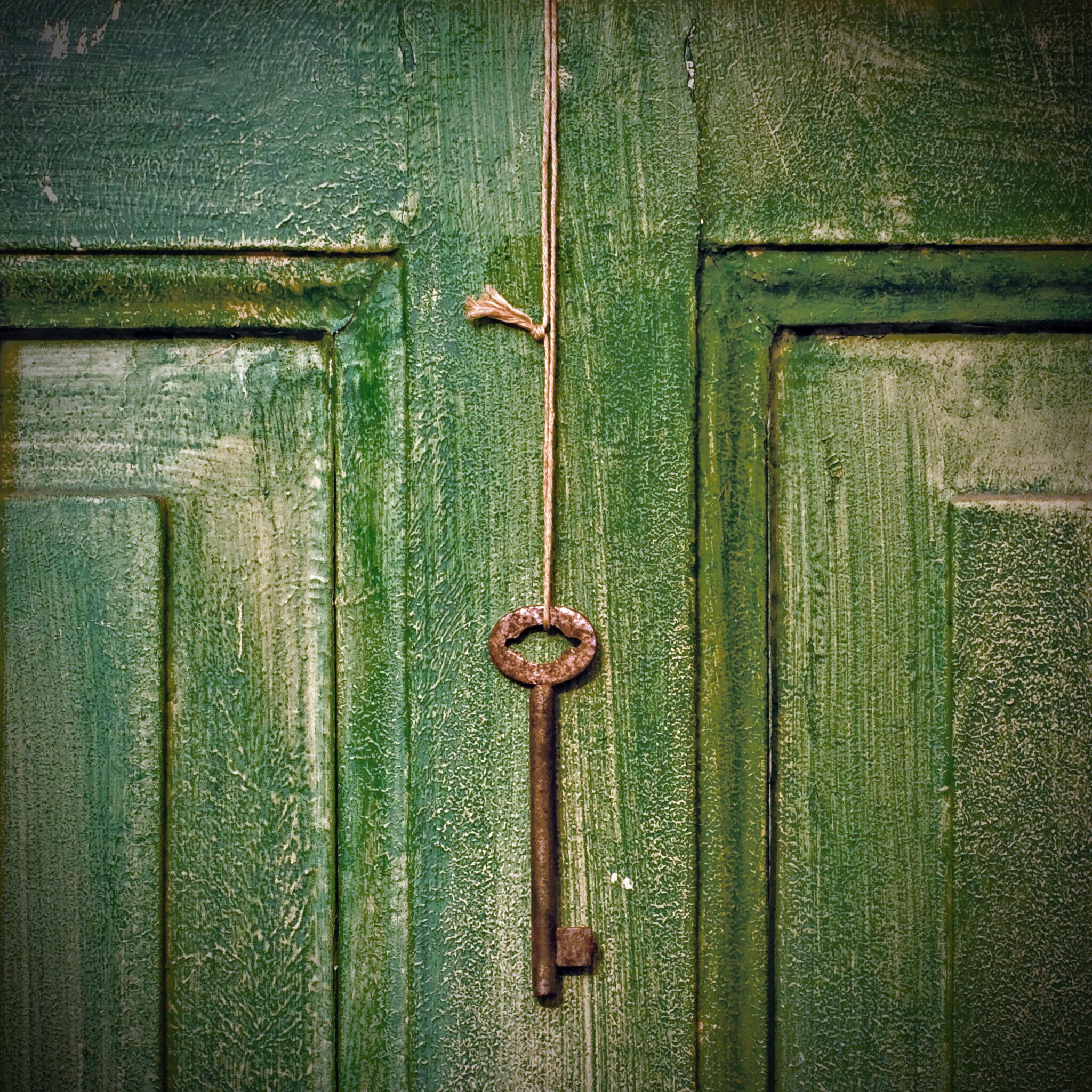 clé rouillée devant une porte verte